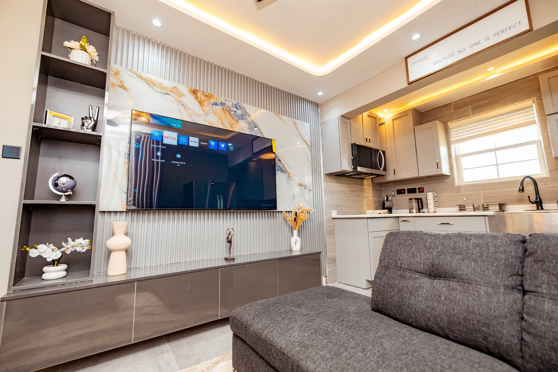 Compact living area with marble TV wall and kitchenette
