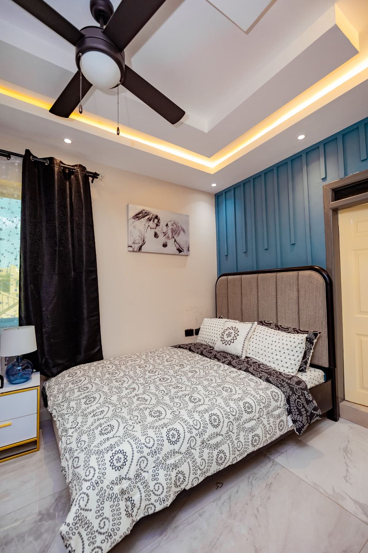Unit 107 bedroom detail with upholstered headboard and bedside lamp