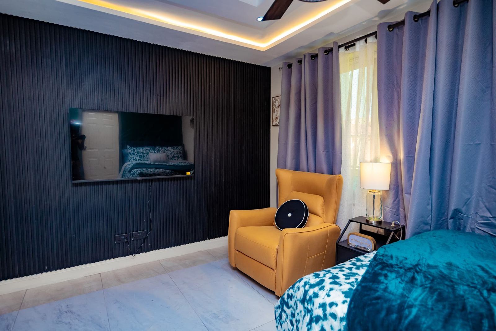 Bedroom with fluted black feature wall and wall-mounted smart TV