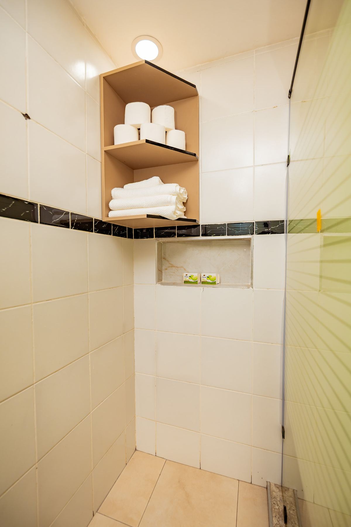 Unit 106 walk-in shower with towel shelving and fresh amenities