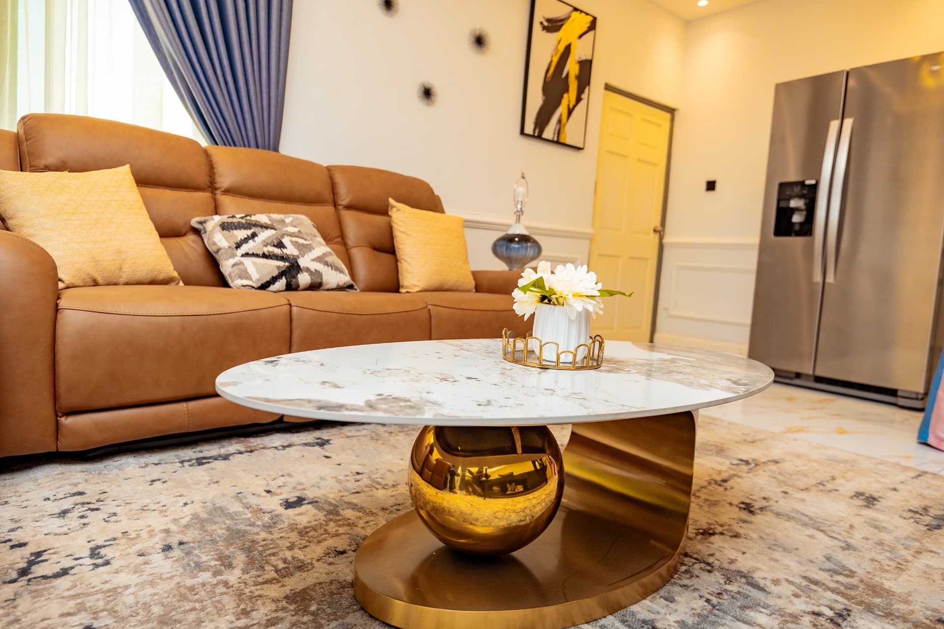 Tan leather sofa with marble and brass coffee table