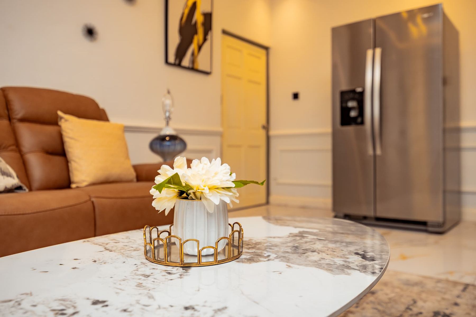 Penthouse marble coffee table detail with fresh flowers and stainless fridge