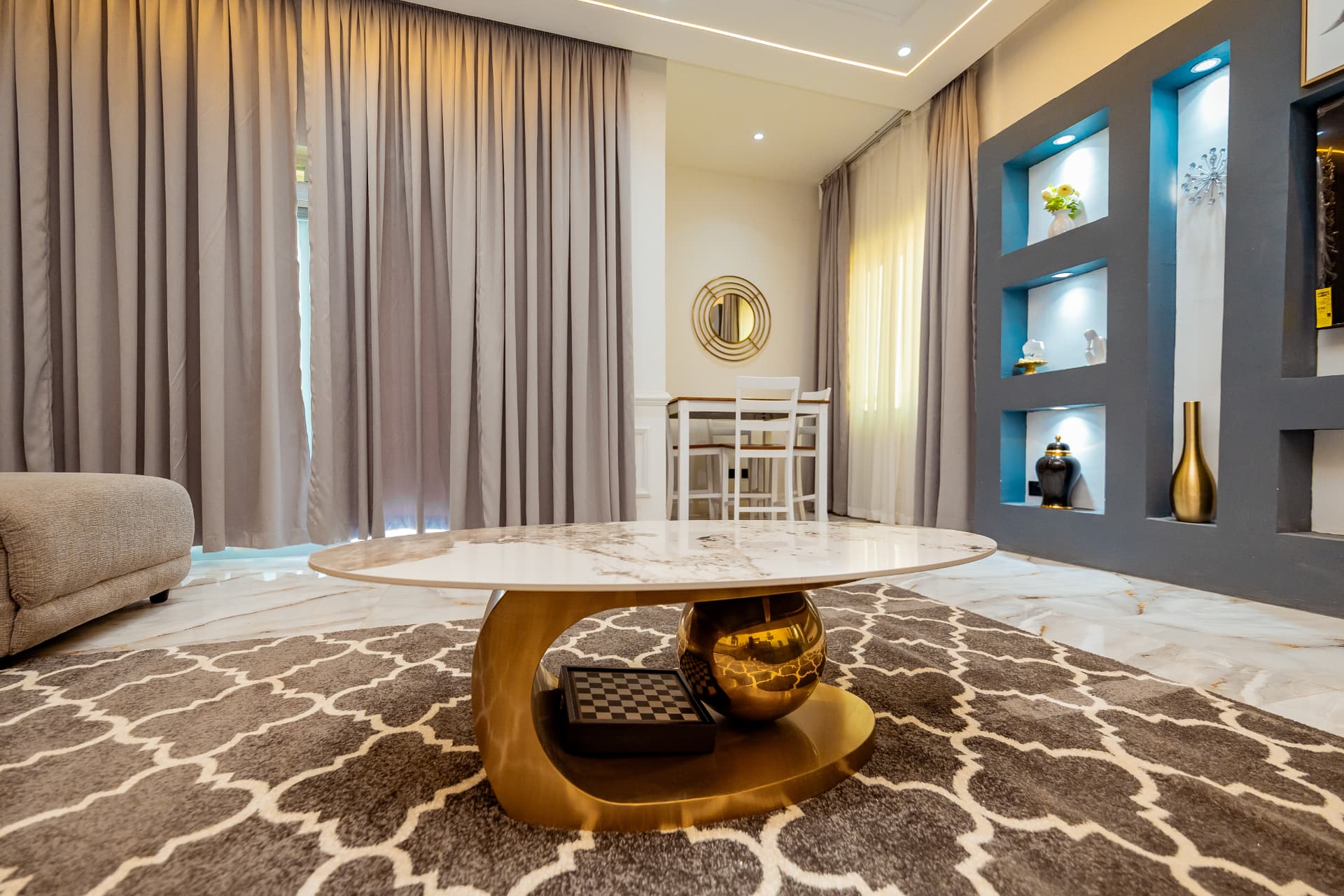 Penthouse lounge with floor-to-ceiling curtains and brass table