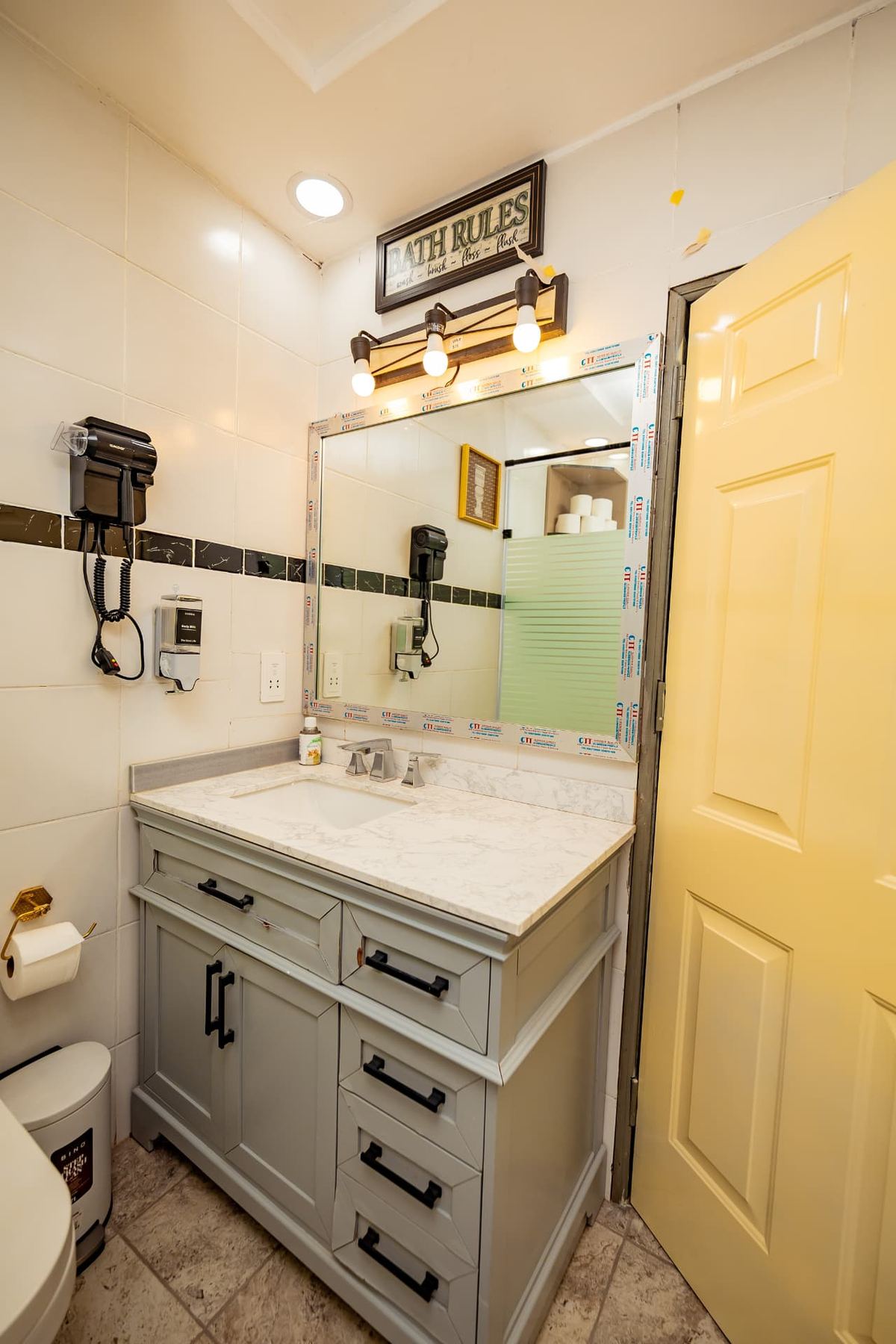 Unit 106 bathroom vanity with marble top, wide mirror and hairdryer